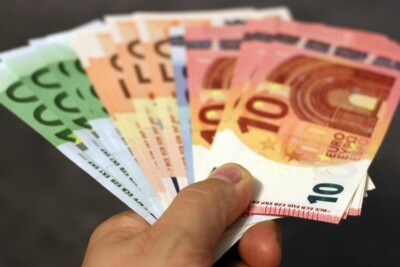 Hand, die Euro-Scheine reicht