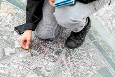 Eine Person kniet auf Boden mit großem Stadtplan
