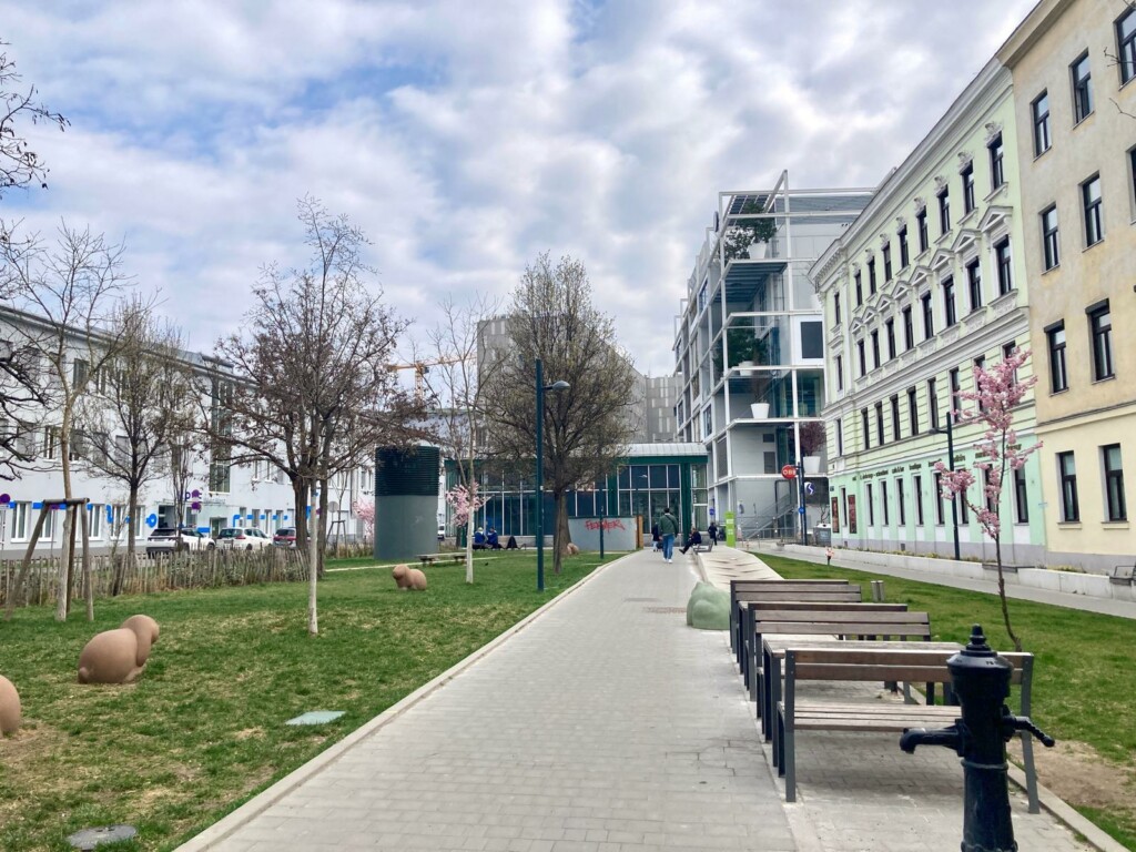 Foto des Gebiets an der Hinterseite des Westbahnhofs mit viel Grün und Blick auf IKEA-Gebäude
