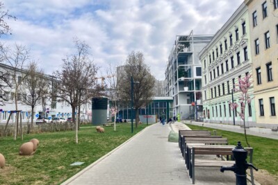 Foto des Gebiets an der Hinterseite des Westbahnhofs mit viel Grün und Blick auf IKEA-Gebäude