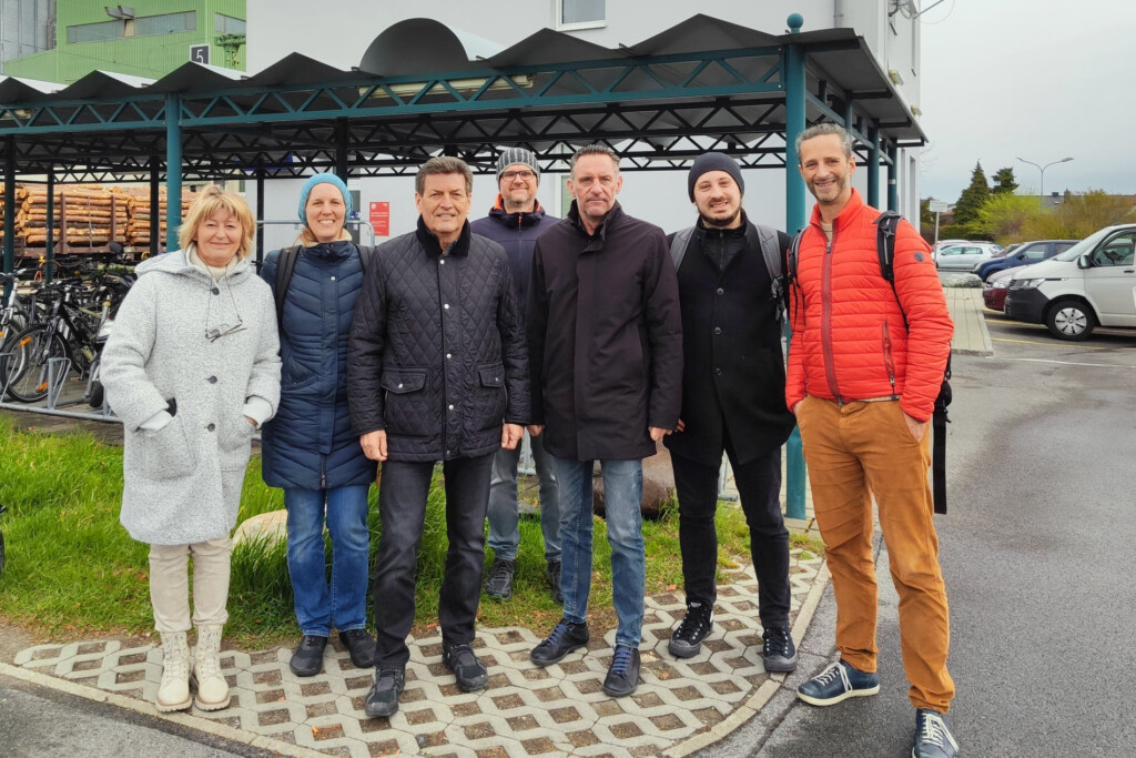 Personengruppe am Bahnhof Deutschkreutz: Karin Steinwendter (Amtsleiterin Deutschkreutz), Katja Arzberger (VOR), Harald Leopold (Bgm. Langenlos), Rainer Rabl (Leiter techn. Infrastruktur Langenlois), Andreas Kacsits (Bgm. Deutschkreutz), Martin Aufhauser (stadtland), Johannes Kellner (Mobilitätszentrale Burgenland). Im Hintergrund ist eine Radabstellanlage und der Bahnhof Deutschkreutz zu sehen.