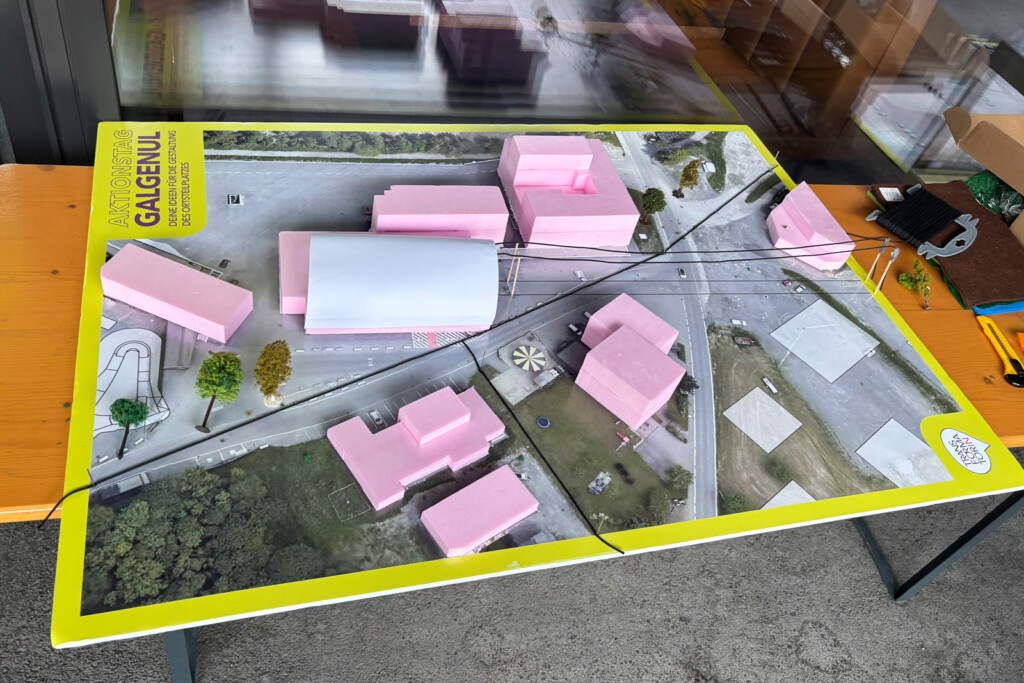 Großer Plan auf einem Tisch. Die Gebäude als einfaches 3D-Modell aus Quadern. Einige Bäume wurden auf dem Plan platziert.