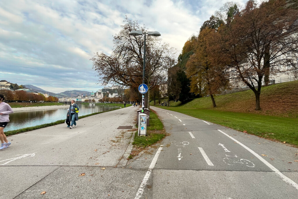 Entlang der Salzach. Ufernah ein Fußweg, durch einen Grünstreifen getrennt daneben ein Zweirichtungs-Radweg
