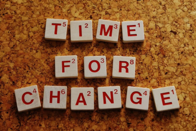 weiße Würfel mit jeweils roten Buchstaben, Angeordnet zu Time for Change