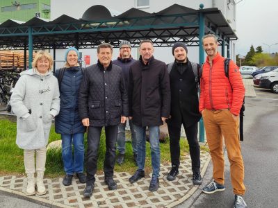 Personengruppe am Bahnhof Deutschkreutz: Karin Steinwendter (Amtsleiterin Deutschkreutz), Katja Arzberger (VOR), Harald Leopold (Bgm. Langenlos), Rainer Rabl (Leiter techn. Infrastruktur Langenlois), Andreas Kacsits (Bgm. Deutschkreutz), Martin Aufhauser (stadtland), Johannes Kellner (Mobilitätszentrale Burgenland). Im Hintergrund ist eine Radabstellanlage und der Bahnhof Deutschkreutz zu sehen.