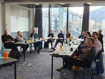 Menschen sitzen an einem U-förmigen Besprechungstisch