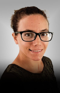 Portrait Cornelia Hebenstreit. Junge Frau dunkelhaarig, mit schwarzer Brille und schwarzer Bluse