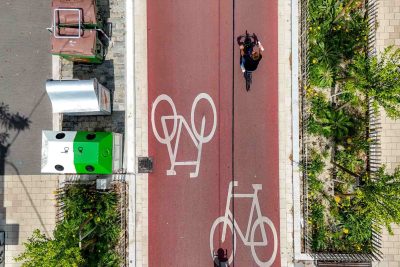 Vogelperspektive auf die Argentinierstraße. Roteingefärbter Asphalt mit Fahrradpiktogrammen und Radfahrenden.